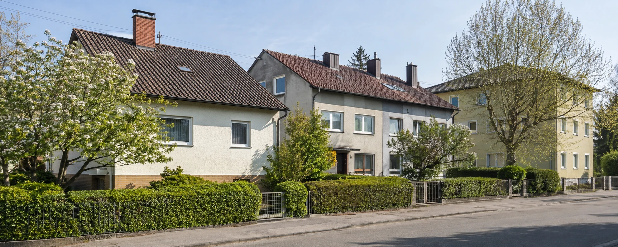 Gepflegte ältere Wohnhäuser in einer begrünten österreichischen Straße